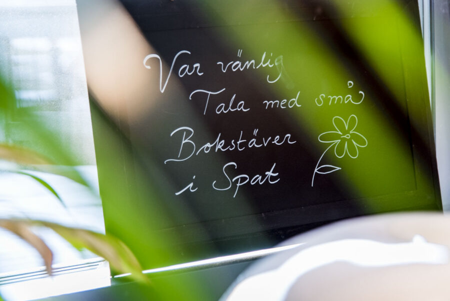 skylt med texten var vänlig tala med små bokstäver i spat