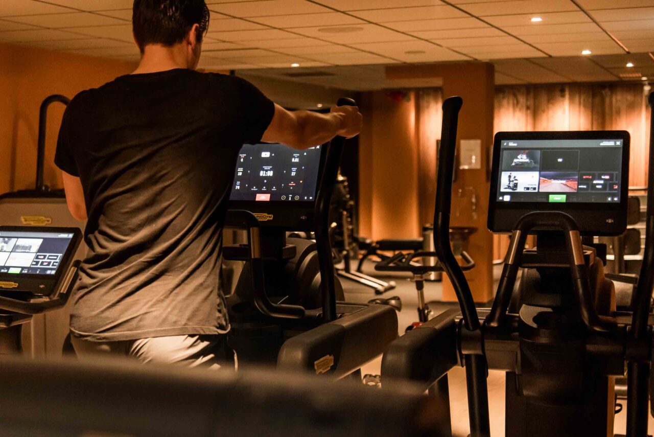 man på crosstrainer i gymmet